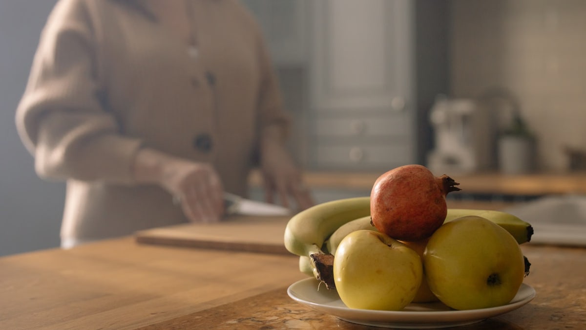 A close-up of fresh fruits on a plate in a cozy kitchen, perfect for healthy diet concepts.